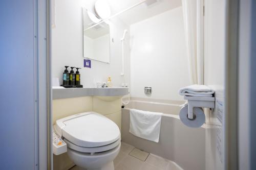 een witte badkamer met een toilet en een wastafel bij Hotel 1-2-3 Takasaki in Takasaki