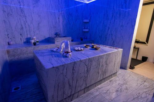 La salle de bains est pourvue d'une baignoire avec un éclairage bleu. dans l'établissement Corp Hotel Apartments and Spa, à Doha