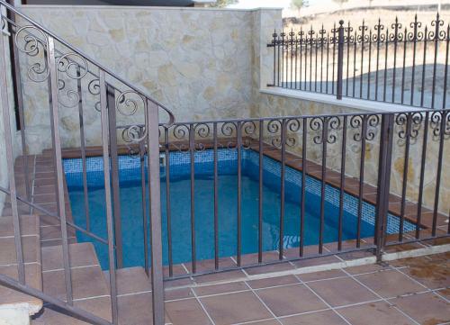 an iron fence around a swimming pool at Casa Rural Paula in Zarzuela del Monte