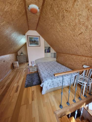 1 dormitorio con 1 cama y suelo de madera en Namelis Rugilė, en Druskininkai