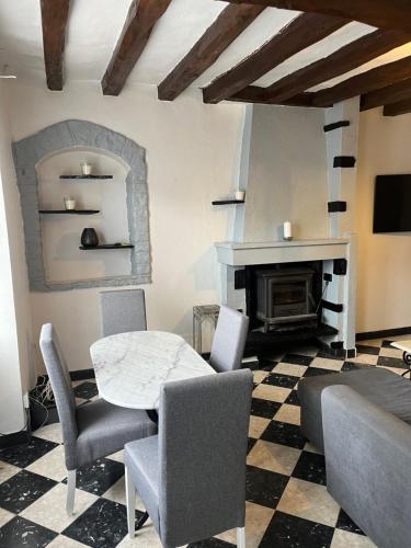 un salon avec une table et des chaises et une cheminée dans l'établissement Stunning 2 bedroom townhouse in pretty village, à Mézières-en-Brenne