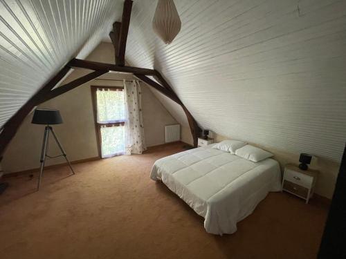 1 dormitorio con 1 cama blanca en el ático en Gite du Domaine Jeanne de Laval, en La Bohalle