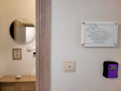 a bathroom door with a sign on the wall at Center River Apartment in Florina