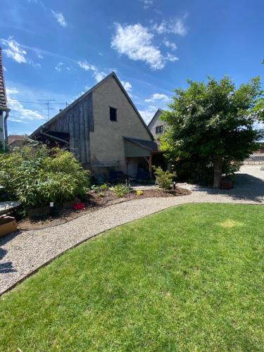 a driveway leading to a barn with a grass yard at Les chambres de la Villa Oberlin in Beblenheim