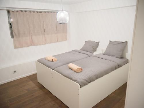 a bed with two pillows on it in a room at Spacieux appartement aux portes de Paris, parking gratuit in Bagnolet