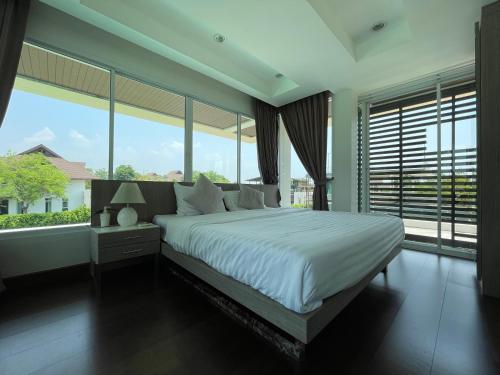 a bedroom with a large bed and large windows at Momento Poolvilla Khaoyai in Ban Khanong Phra Nua