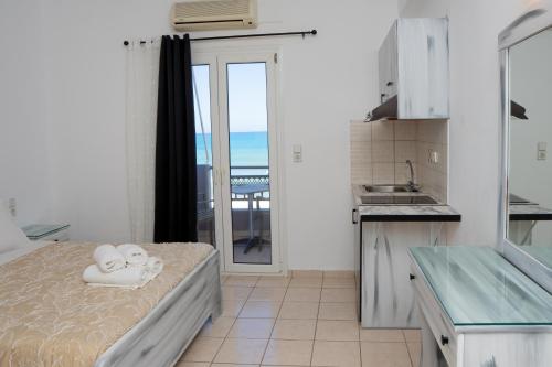 a kitchen with a bed and a view of the ocean at ARTEMIS beach studios in Kalamaki Heraklion