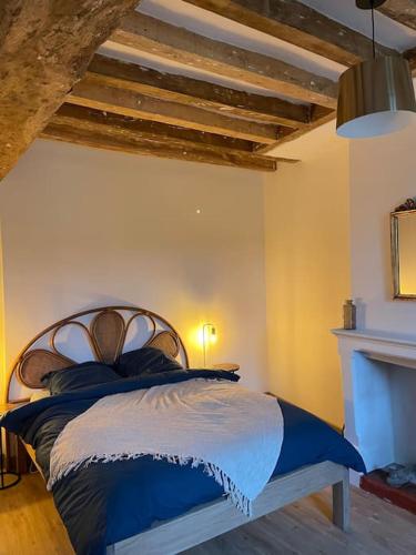 une chambre avec un lit avec des draps bleus et blancs dans l'établissement Maison bord de Loire, à Saint-Clément-des-Levées