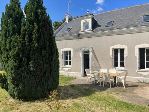 a table and chairs in front of a house at Maison bord de Loire in Saint-Clément-des-Levées