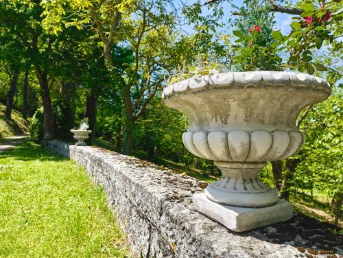un gran jarrón de hormigón sentado en una pared de piedra en Casa Barattini, en Zocchetta