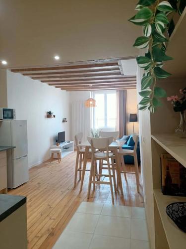 une cuisine et un salon avec une table et des chaises dans l'établissement De ville en vignes, à Villefranche-sur-Saône