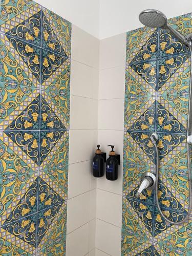 a bathroom with a shower with a blue and yellow tiles at Villa Da Vinci Luxury Panoramic Apartments - Taormina rooms collection in Taormina
