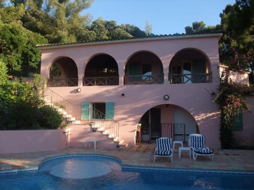 une maison avec une piscine devant dans l'établissement Villa Cap Benat piscine vue mer, à Bormes-les-Mimosas