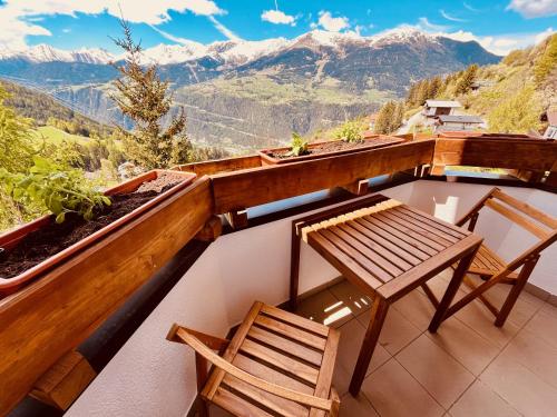 2 Stühle und ein Tisch auf einem Balkon mit Bergblick in der Unterkunft Landhaus Sonnrain Fendels in Fendels