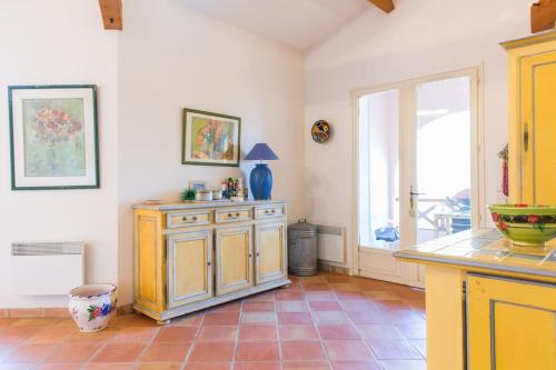 une cuisine avec une armoire jaune et une fenêtre dans l'établissement Villa Cap Benat piscine vue mer, à Bormes-les-Mimosas