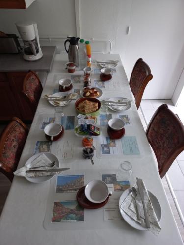 布朗托姆的住宿－Au Dolmen，桌子上摆着盘子和餐具