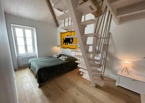 une chambre avec un lit et un escalier en colimaçon dans l'établissement Les 4 Belles maison Ile de Ré, à Sainte-Marie de Ré