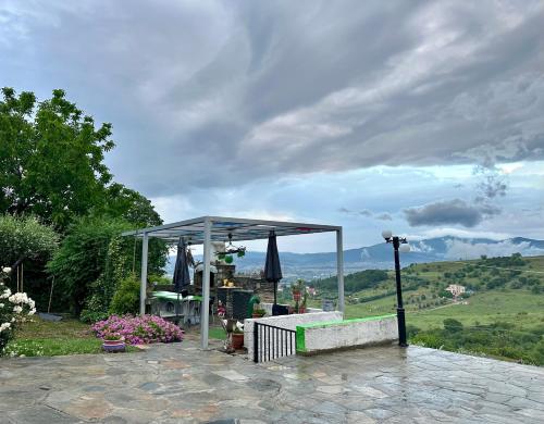 a gazebo with a table and an umbrella at Archontiko Alexandros Luxury Suites in Kardiá