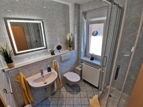 een badkamer met een wastafel, een toilet en een douche bij Ferienwohnung Hidde in Ostseebad Koserow