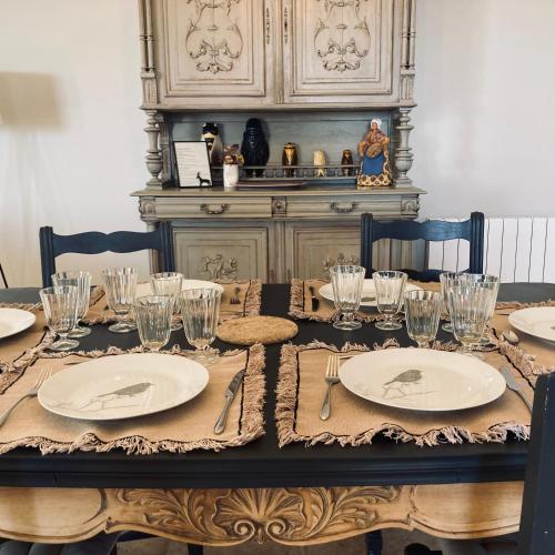 a table with plates and glasses on top of it at Les Mas d'Azur Appartement in Vence