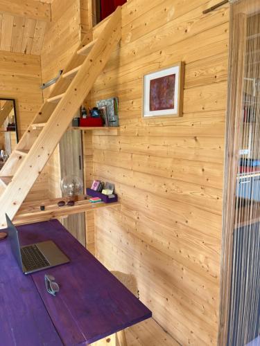 une cabane en bois avec un ordinateur portable sur une table dans l'établissement Cabane de Mardil, à Aubazines