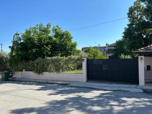 a black and white fence in front of a driveway at Zeusplace Magic Villa in Aigínion