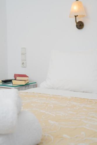a bedroom with a bed with a table with a lamp at ARTEMIS beach studios in Kalamaki Heraklion