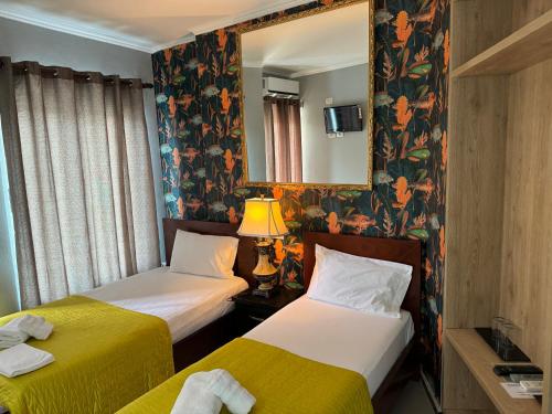 Habitación de hotel con 2 camas y espejo en Hotel Royal Saranda, en Sarandë