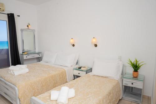 a bedroom with two beds and a mirror at ARTEMIS beach studios in Kalamaki Heraklion