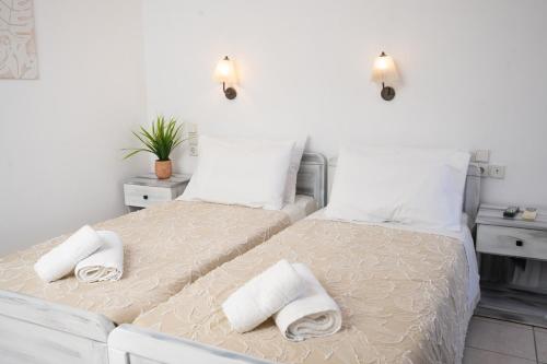 a bedroom with two beds with towels on them at ARTEMIS beach studios in Kalamaki Heraklion