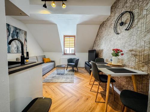 a kitchen and living room with a table and chairs at Rezidencia Levočský Pivovar in Levoča