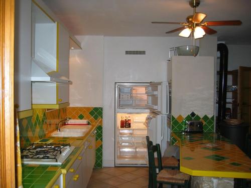 une cuisine avec un réfrigérateur et un plan de travail dans l'établissement L'Ile Aux mimosas, à Vaison-la-Romaine