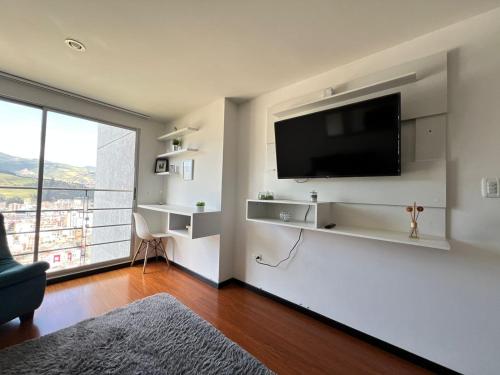 sala de estar con TV de pantalla plana en la pared en Apto completo Atures la mejor vista y ubicación!, en Pasto