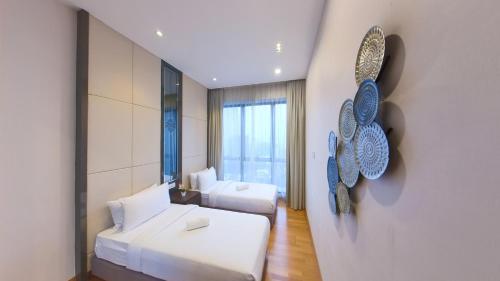 1 dormitorio con 2 camas y una pared de arte de mariposa en Dorsett Serviced Suites Kuala Lumpur, en Kuala Lumpur