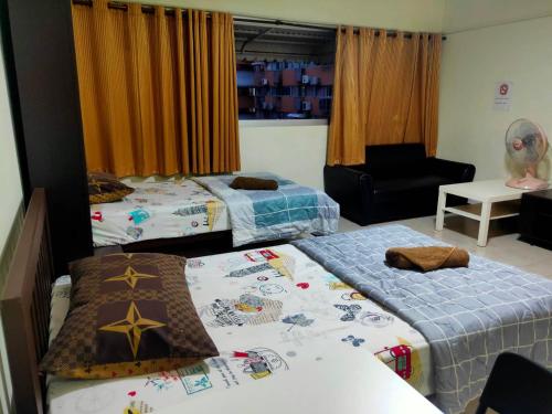 a bedroom with two beds and a chair and a couch at ป็อปปูล่าคอนโด เมืองทองธานี ใกล้ Impact 酒店 公寓 in Thung Si Kan