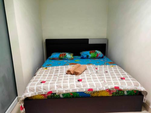 a bed with a stuffed animal laying on it at ป็อปปูล่าคอนโด เมืองทองธานี ใกล้ Impact 酒店 公寓 in Thung Si Kan