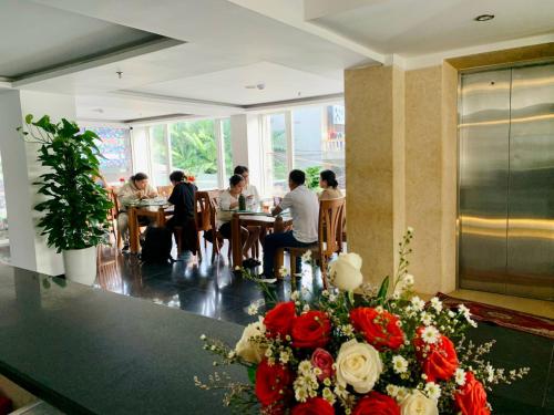 a group of people sitting at tables in a restaurant at Việt Nam Hotel in Hue