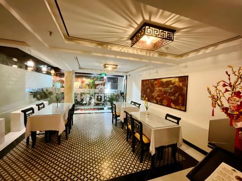 a dining room with tables and chairs in a restaurant at Việt Nam Hotel in Hue