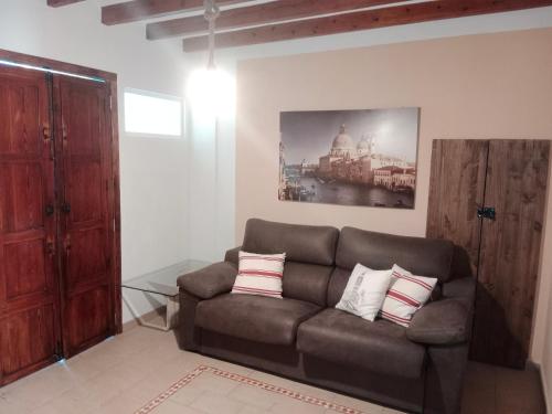 a living room with a brown couch with pillows at La Milotxa in Adsubia