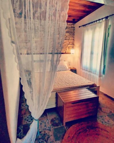 a bedroom with a bed with a curtain at Vasilis' kalivi in Skiathos