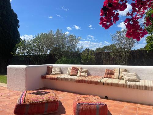 a couch sitting on a patio with two ottoman at Authentic Villa with amazing pool in Santa Gertrudis de Fruitera