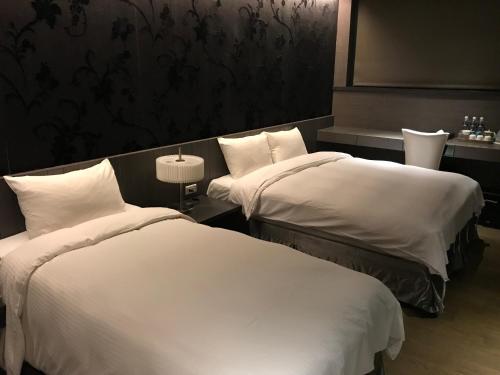 台北的住宿－山水樂會館，配有白色床单的酒店客房内的两张床