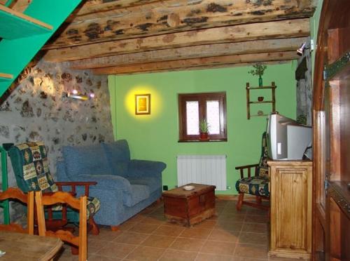 sala de estar con sofá azul y paredes verdes en Casa Ramón La Caseta, en Sin