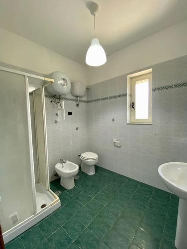 a bathroom with two toilets and a shower and a sink at Casa vacanza Palinuro in Palinuro