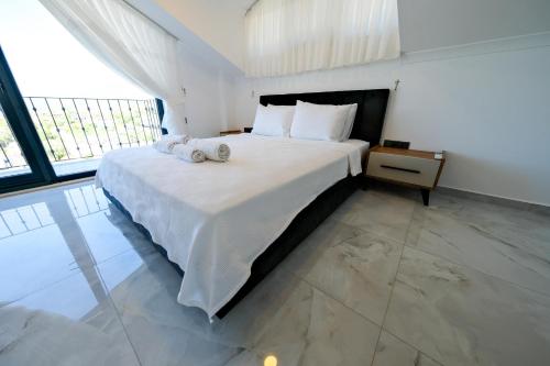 a bedroom with a large bed with two towels on it at Oasis Family-Friendly Luxury Villa Fethiye Oludeniz by Sunworld Villas in Fethiye
