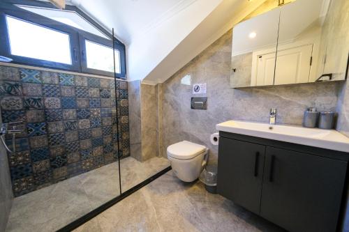 フェティエにあるOasis Family-Friendly Luxury Villa Fethiye Oludeniz by Sunworld Villasのバスルーム(トイレ、洗面台付)、窓が備わります。