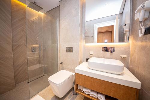ein Bad mit einem WC, einem Waschbecken und einer Dusche in der Unterkunft Nobbu Hotel Ksamil in Ksamil