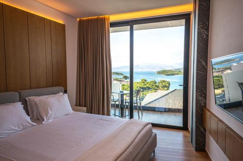 a hotel room with a bed and a large window at Nobbu Hotel Ksamil in Ksamil