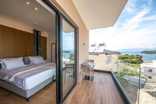 a bedroom with a bed and a view of the ocean at Nobbu Hotel Ksamil in Ksamil