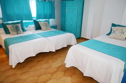 two beds in a room with blue and white at Hotel Marazul in Mojácar